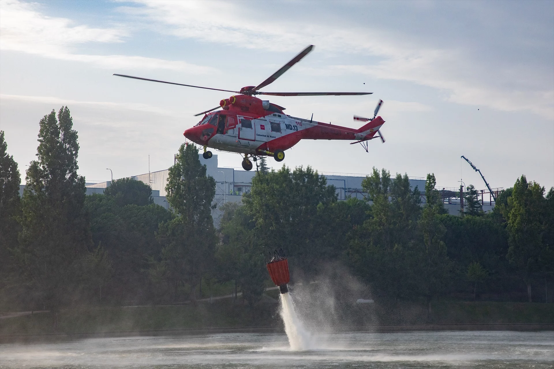 Un helicóptero recoge agua de un estanque cercano al incendio, a 12 de agosto de 2025, en Tres Cantos, Madrid (Fuente: Agencias)