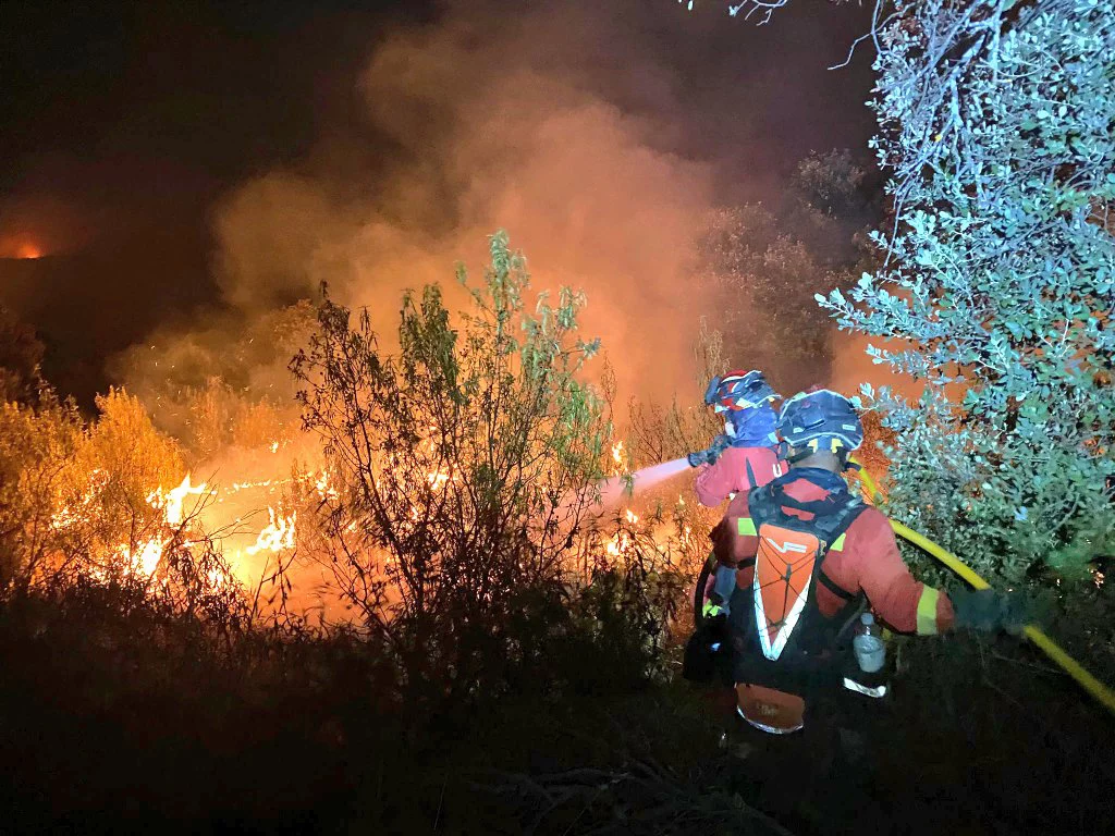 Dos agentes de la Unidad Militar de Emergencias (UME) trabajan en las labores de extinción del incendio, a 12 de agosto de 2025, en Tres Cantos, Madrid (Fuente: Agencias)
