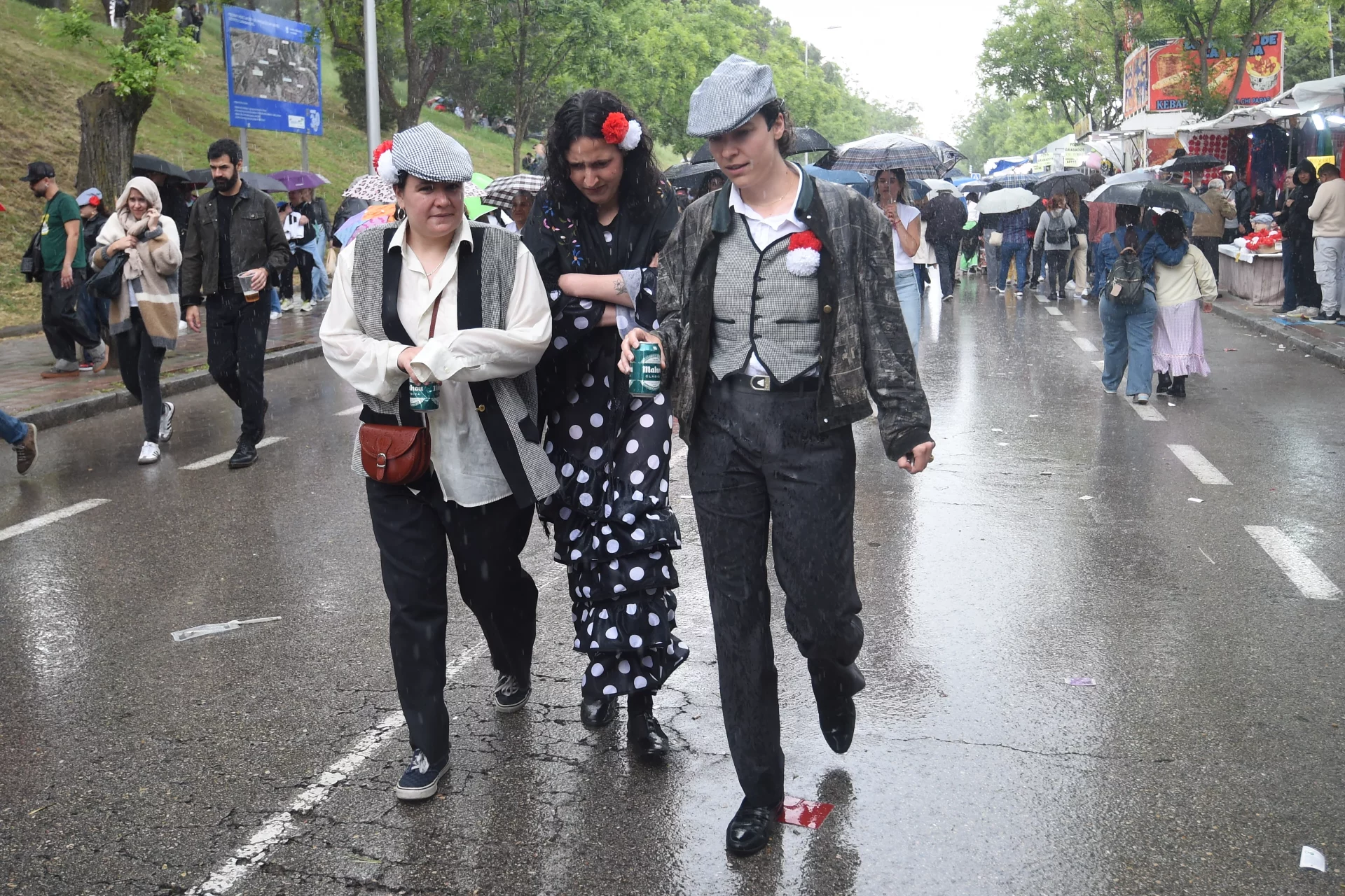 Varias personas se protegen de la lluvia en la pradera de San Isidro, a 15 de mayo de 2025, en Madrid. Fuente: Agencias
