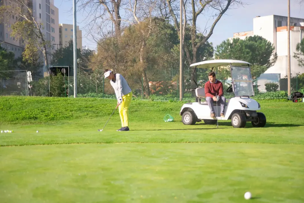 Dos golfistas disfrutando de un juego en un hermoso campo verde en Portugal.